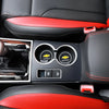 Interior view of a car showing red and black leather upholstery and an electronic control panel.