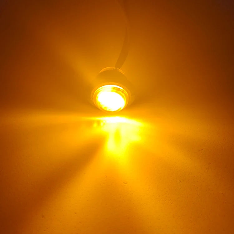 Feu de position LED clair projetant un faisceau jaune-orange puissant sur une surface.