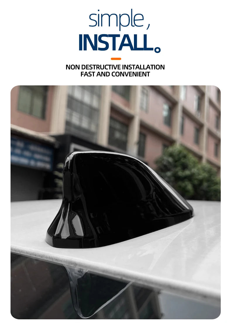 Black shark fin roof antenna cover placed on a white surface.