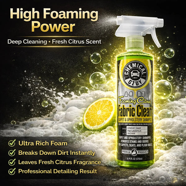 A bottle of Chemical Guys Fabric Clean citrus cleaner with a spray nozzle and citrus fruit visible on a dark background.