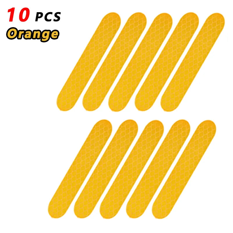 Ten orange reflective safety stickers or tape pieces arranged in a row.
