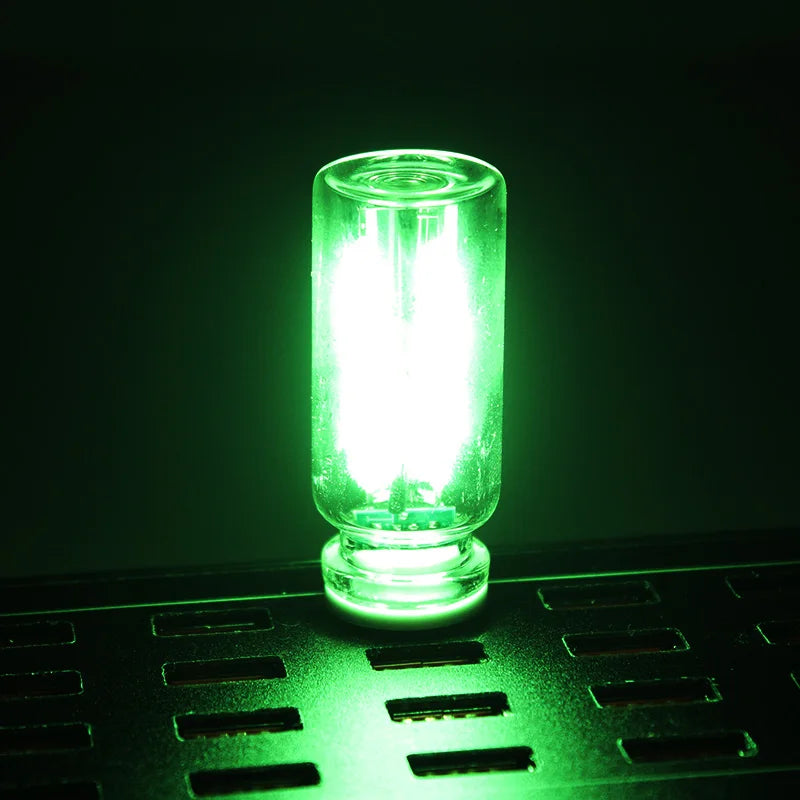 Ein hellgrüner USB-Auto-Nachtlicht leuchtet auf einer dunklen Oberfläche.