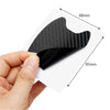 A hand holds a black car door handle protection film, showing its texture and dimensions.