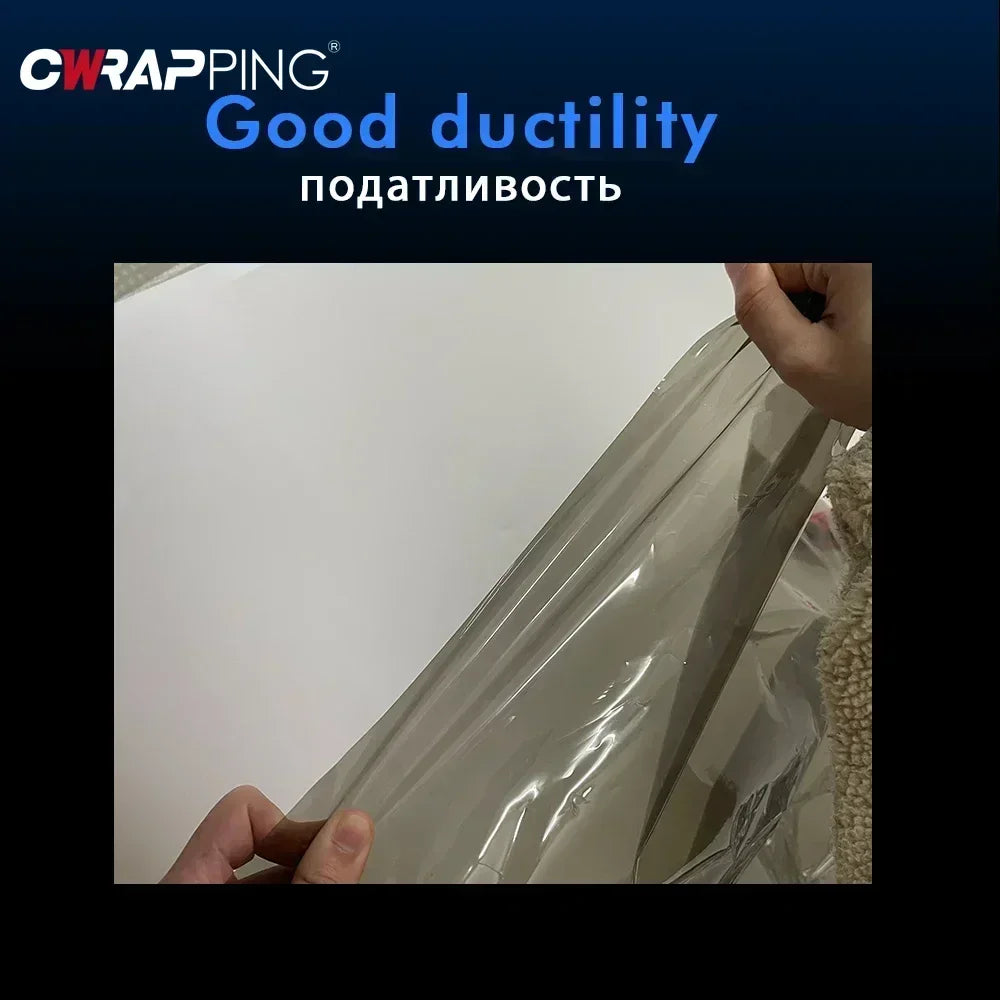 A hand is holding a clear automotive tint film, demonstrating its good ductility for car lights.