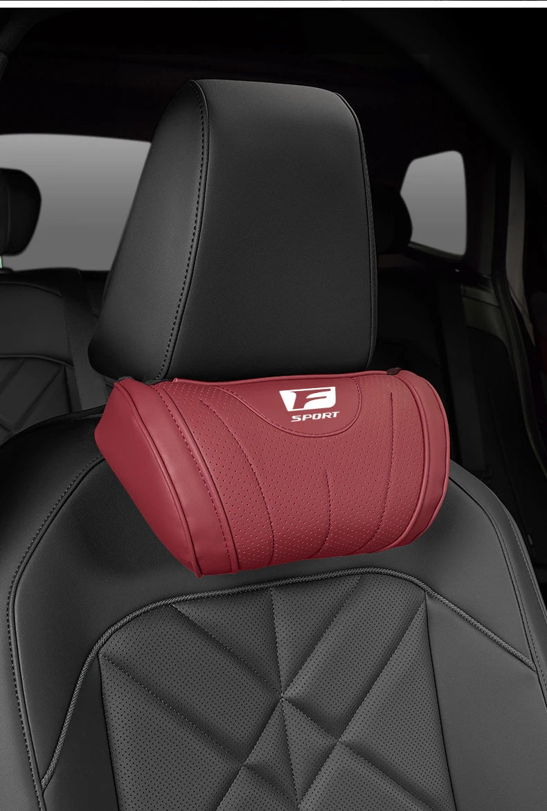 A red ergonomic neck pillow with an F Sport logo is placed on a black car seat.