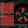 Autocollants réfléchissants rouges disposés en lignes verticales sur une jante de voiture sombre.