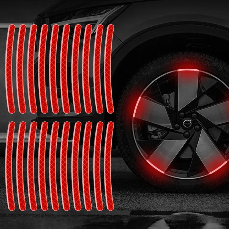 Autocollants réfléchissants rouges disposés en lignes verticales sur une jante de voiture sombre.