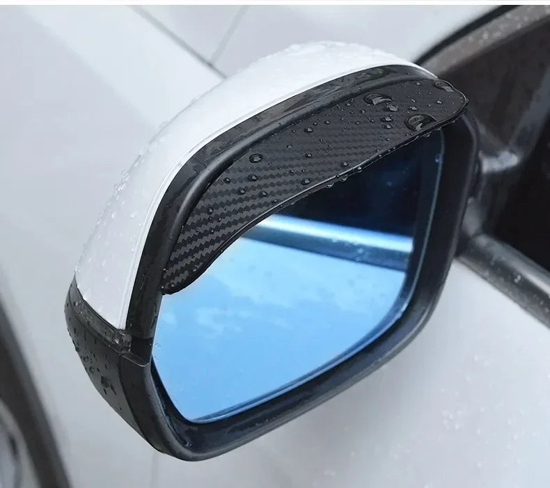 A close-up view of a carbon fiber car rain visor attached to a rearview mirror.