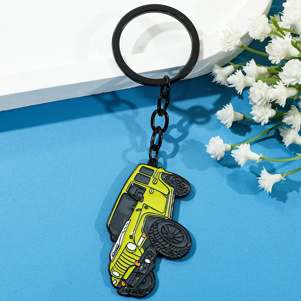 A yellow classic alloy car keychain with a tire, attached to a black keyring.