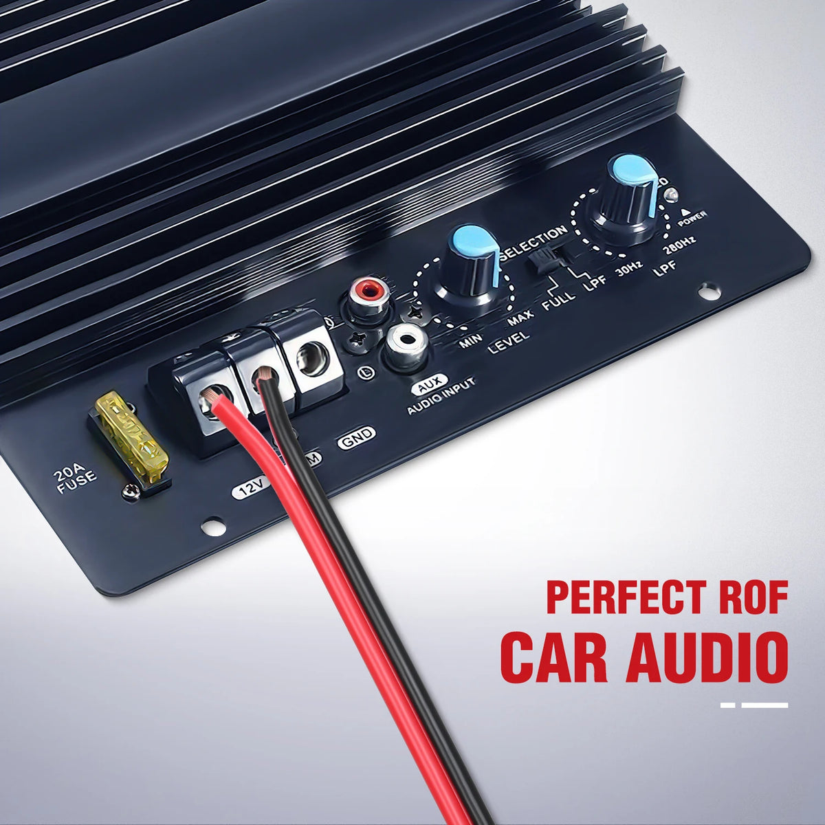 A dark electronic module with controls and a red wire connected to it, used for car audio systems.