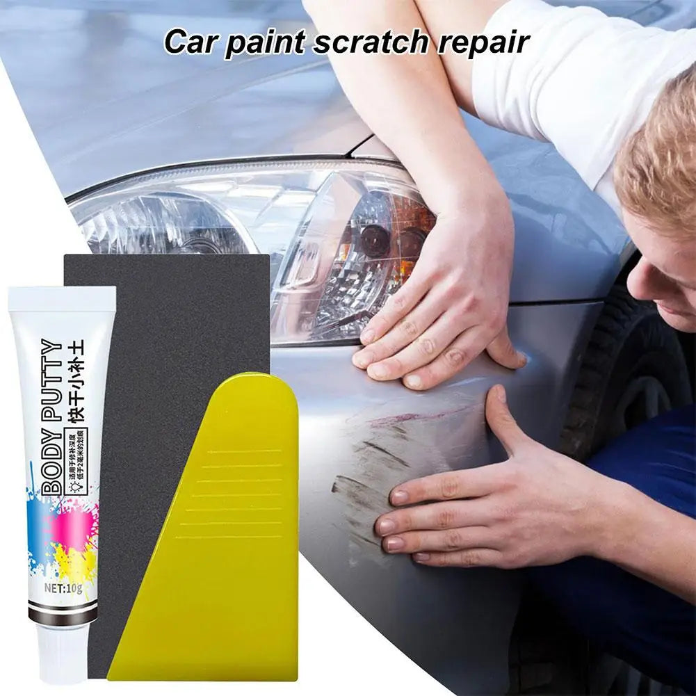 Une main applique de la pâte corporelle pour réparer les rayures sur la peinture d'une voiture.