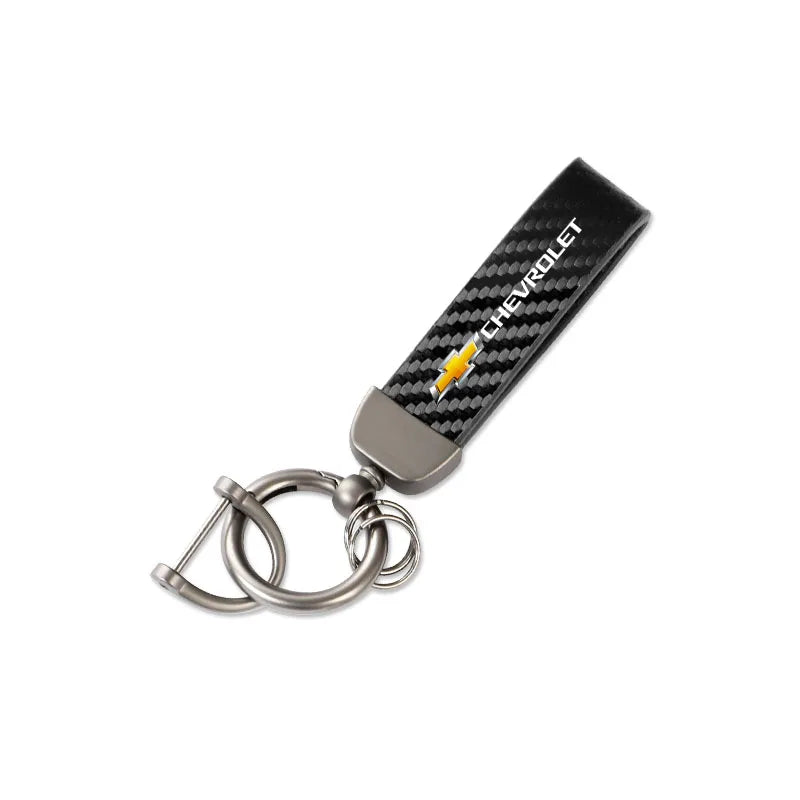 A black checkered leather key fob with a metal ring attached, part of a luxury metal car keyring set.