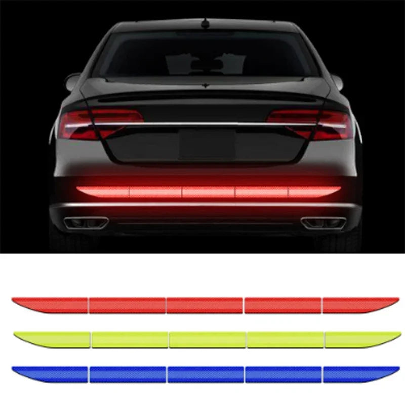 A rear view of a car with five reflective safety stickers in red, yellow, and blue arranged horizontally.