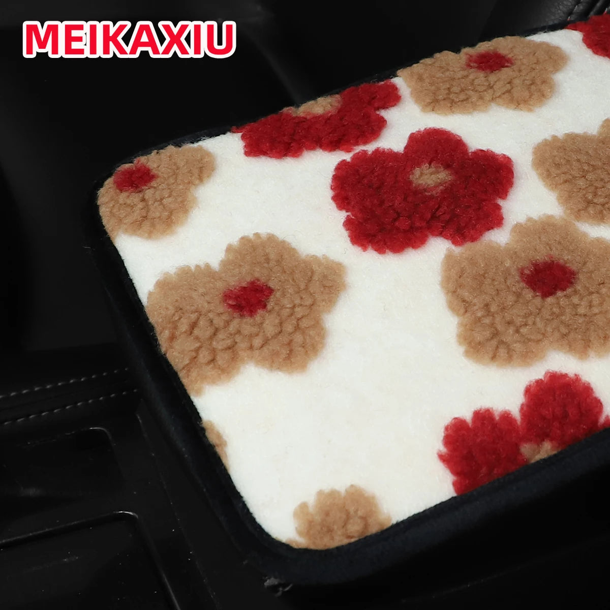 A plush car armrest cushion featuring a pattern of white, red, and brown floral shapes.