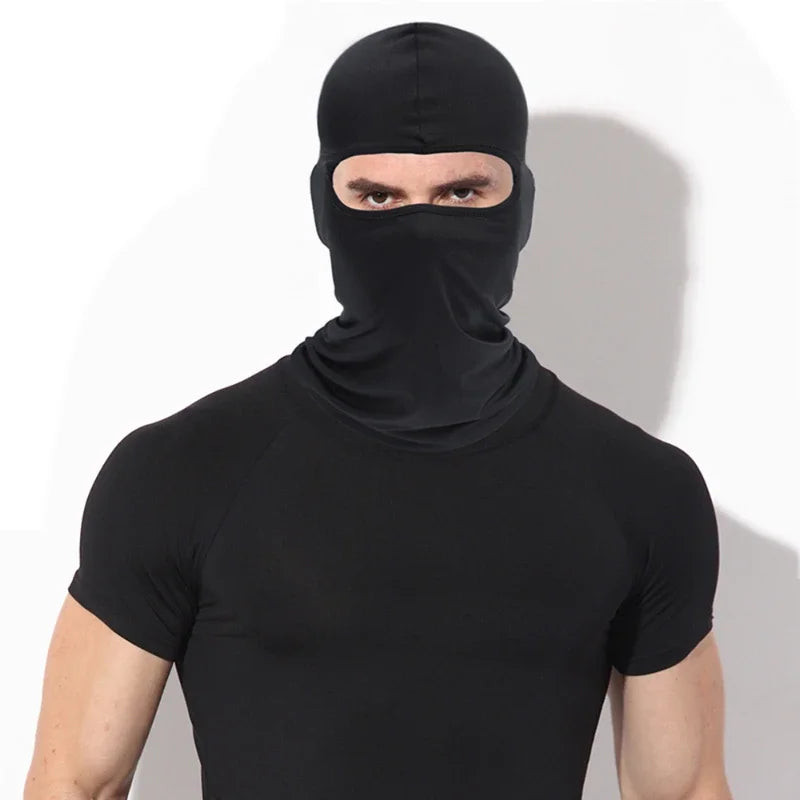 A man wearing a black all-weather windproof balaclava face mask and black shirt.