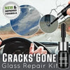 A close-up of a hand applying repair resin to a cracked car windshield glass.