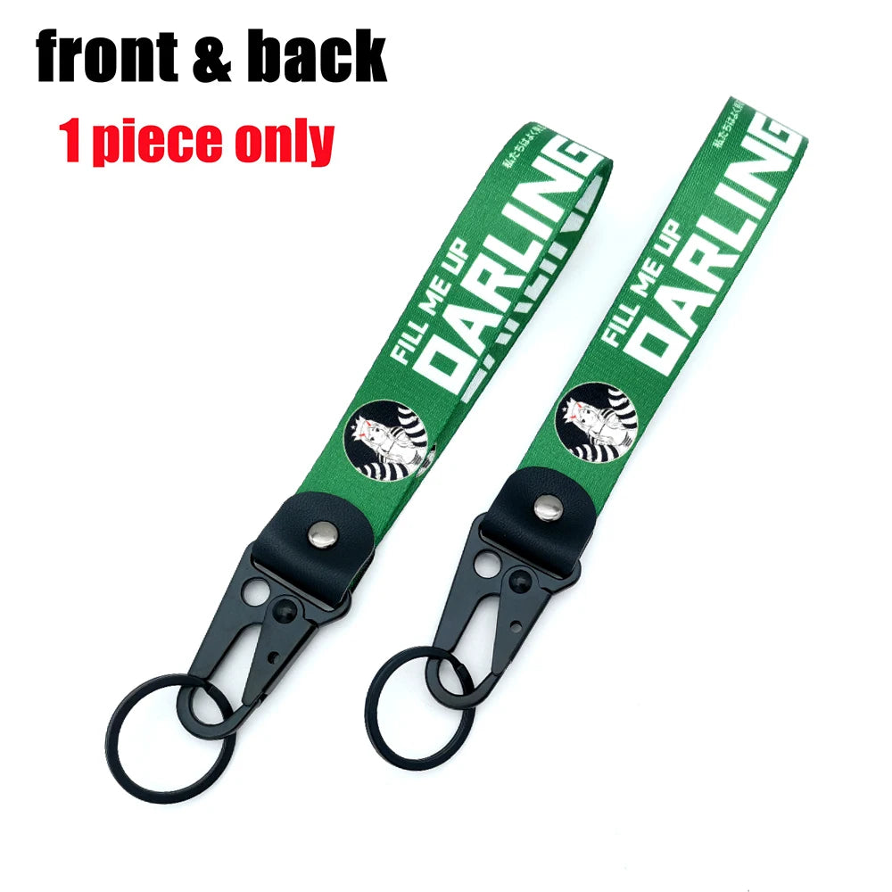 Ein grüner Lanyard mit dem Text FILL ME UP DARLING und einer schwarzen Clips