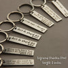 A collection of engraved stainless steel keychains featuring various heartfelt messages and names.