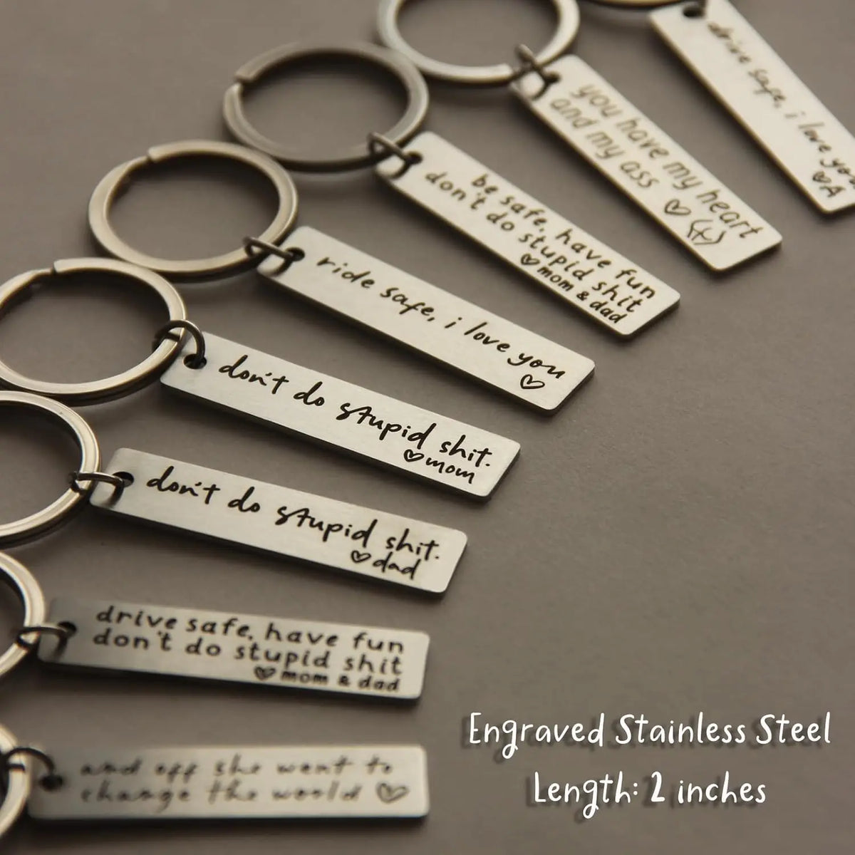 A collection of engraved stainless steel keychains featuring various heartfelt messages and names.