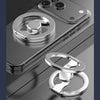 A silver magnetic phone ring stand with a dual-sided grip is shown resting on a dark surface.