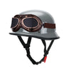 A silver half-helmet with brown goggles and a black strap harness for motorcycle or EV safety.