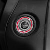 Close-up of a black ignition push button cover with a central circular design featuring red lights and START/STOP text.