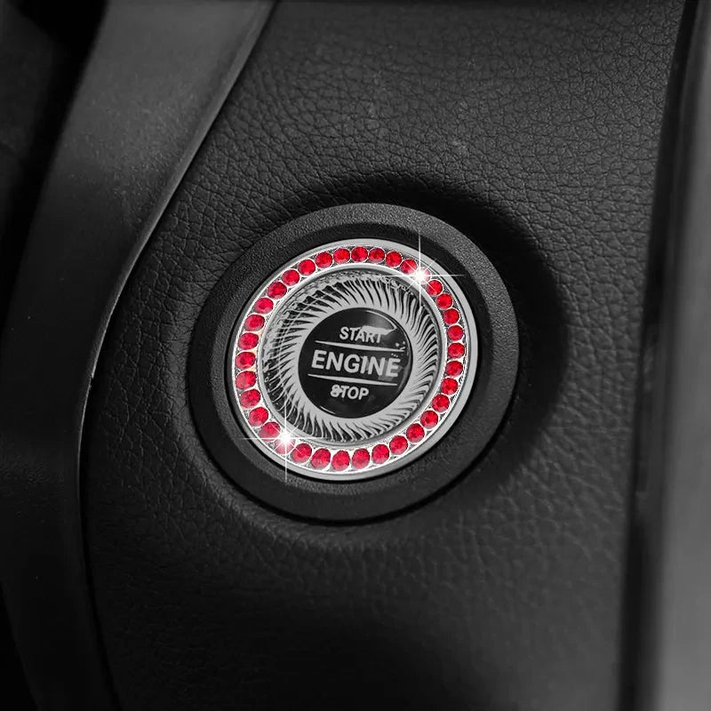 Close-up of a black ignition push button cover with a central circular design featuring red lights and START/STOP text.