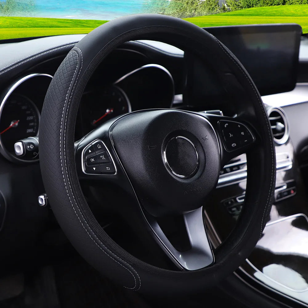 Close-up view of a black leather steering wheel cover inside a car cabin.