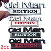 A set of three metal emblems featuring the text Old Man EDITION in various colors and finishes.