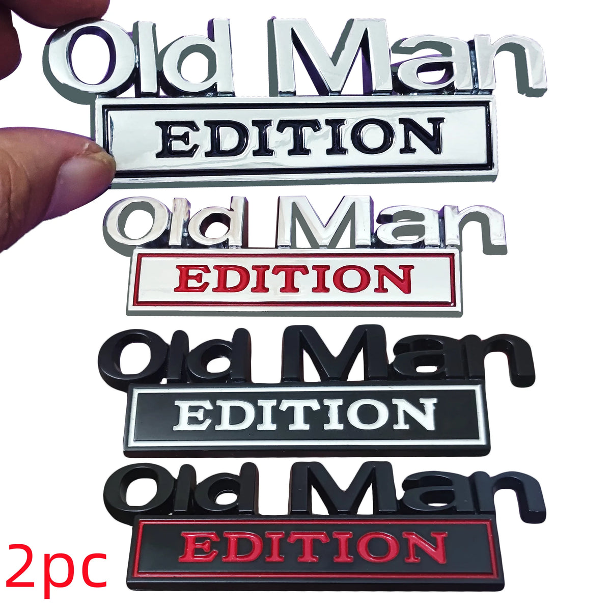 A set of three metal emblems featuring the text Old Man EDITION in various colors and finishes.