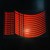 A pattern of red reflective stickers shaped like curved lines on a dark background.