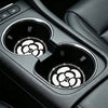 Close-up of car cup holders with decorative non-slip coasters visible in the interior