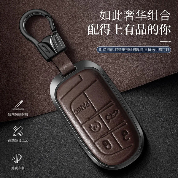 A dark brown genuine leather car key fob cover with a silver metal clasp and embossed panic buttons resting on a dark surface