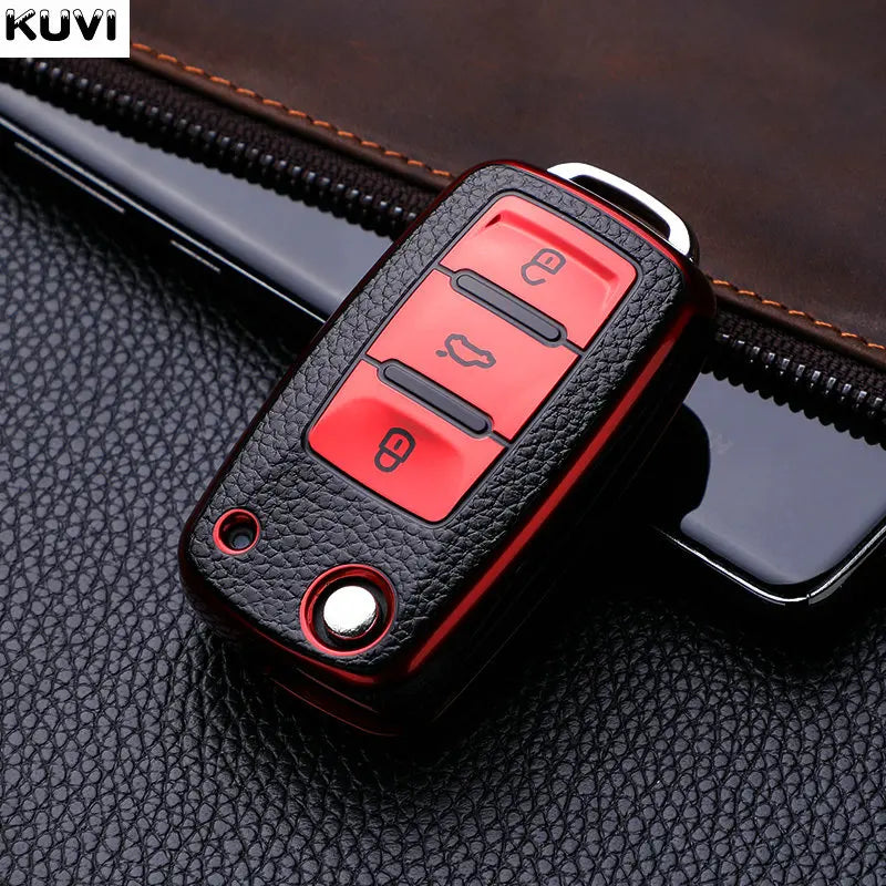 A red TPU car key cover with multiple buttons is shown resting on a black leather surface.