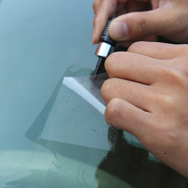 A hand is using a tool to repair a crack on a car window with a glass repair kit.