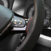 Close-up of a black perforated steering wheel cover with an OK view button and a red marking on the grip.