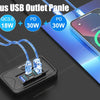 A black 4-port USB outlet panel with four blue cables and a smartphone charging on a blue surface.