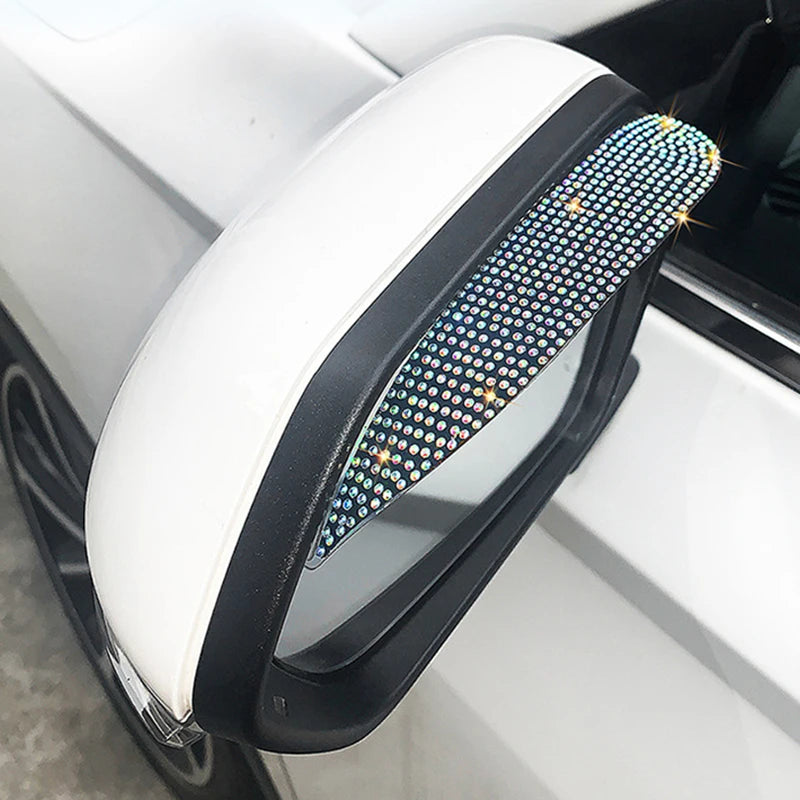 A white rhinestone visor is installed on a car's rearview mirror for enhanced visibility.