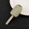 A light green TPU car key fob cover with a metal blade is placed on a white plate.