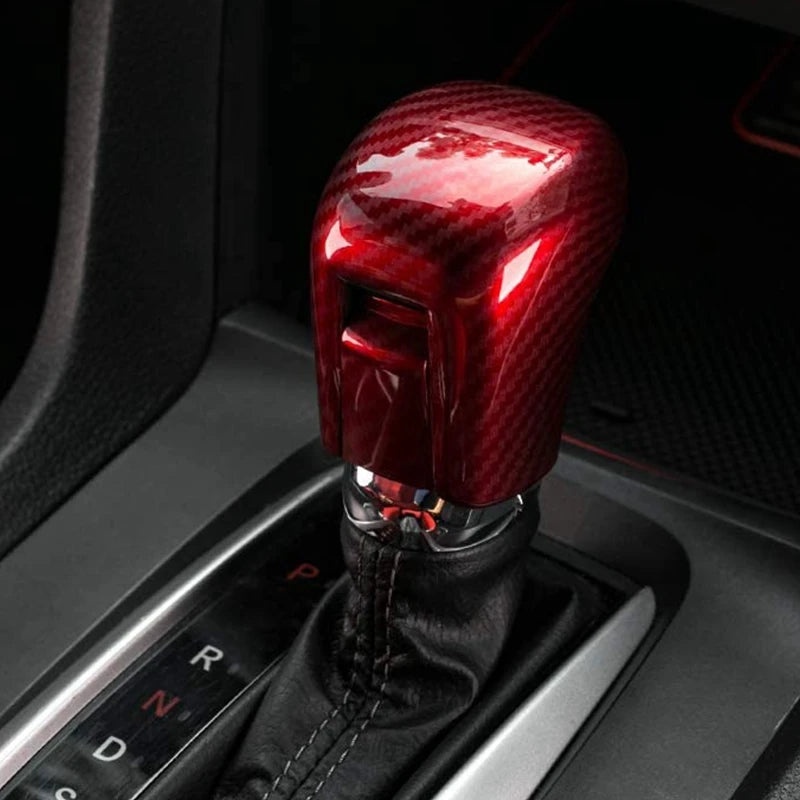 Close-up of a glossy red carbon fiber gear shifting knob cover for a Honda Civic.