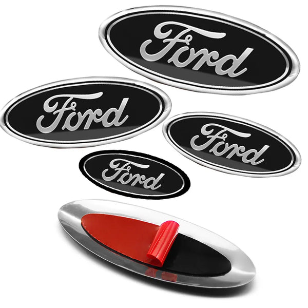 A collection of silver Ford aluminum hood and trunk emblem badges and stickers.