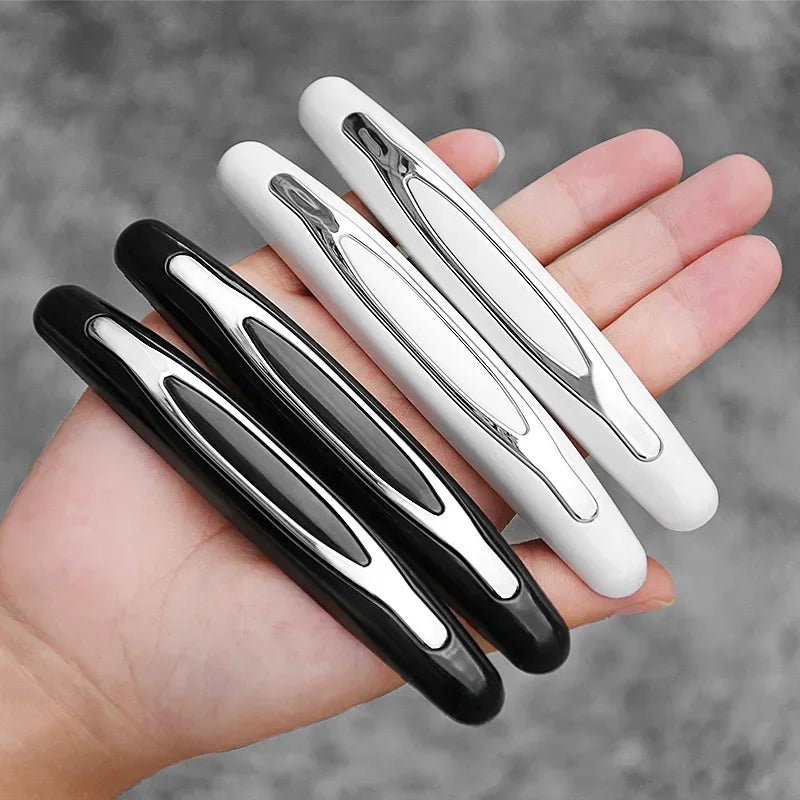A hand holds several black and white car door edge protection strips.
