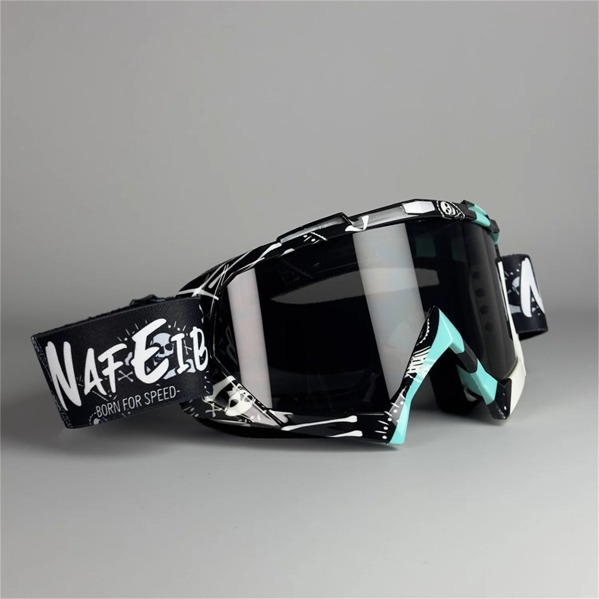 A pair of black and white off-road motorcycle riding goggles with a teal accent frame.