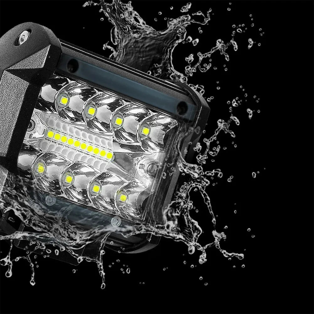 A high-intensity LED off-road flood bar is shown being splashed by water against a black background.