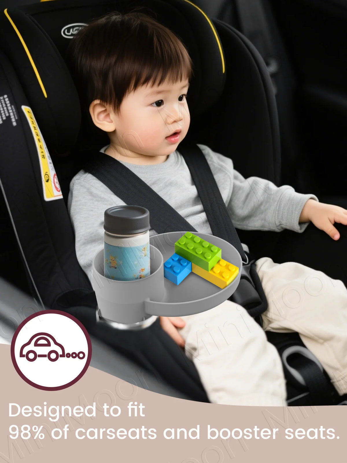 A baby is seated in a car seat with an expandable travel tray designed to fit 98% of car seats and booster seats.