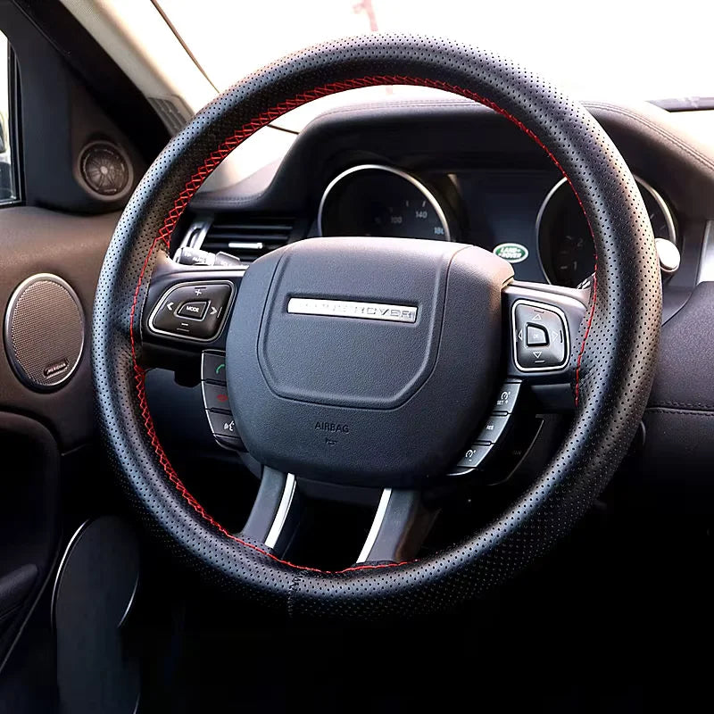 Close-up view of a black steering wheel with leather grips and controls inside a car