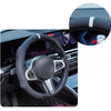Close-up view of a black steering wheel with silver accents and a white accent stripe on the rim.