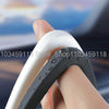 A hand is holding a silicone screen frame protector for a car, showing the white and black protective frame.