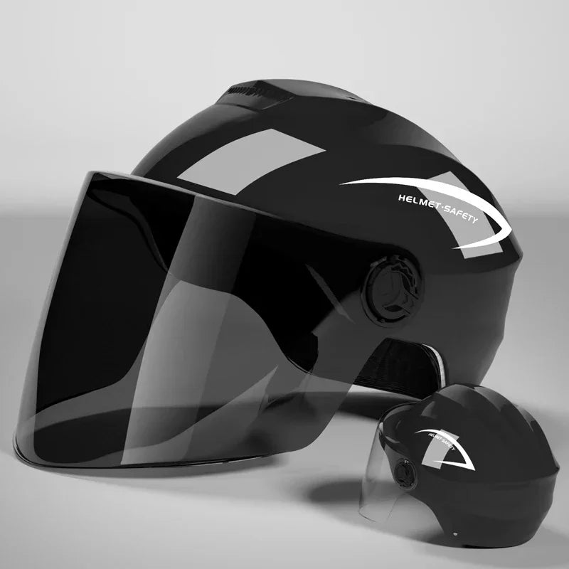 A glossy black half helmet with a clear visor is shown on a gray surface.