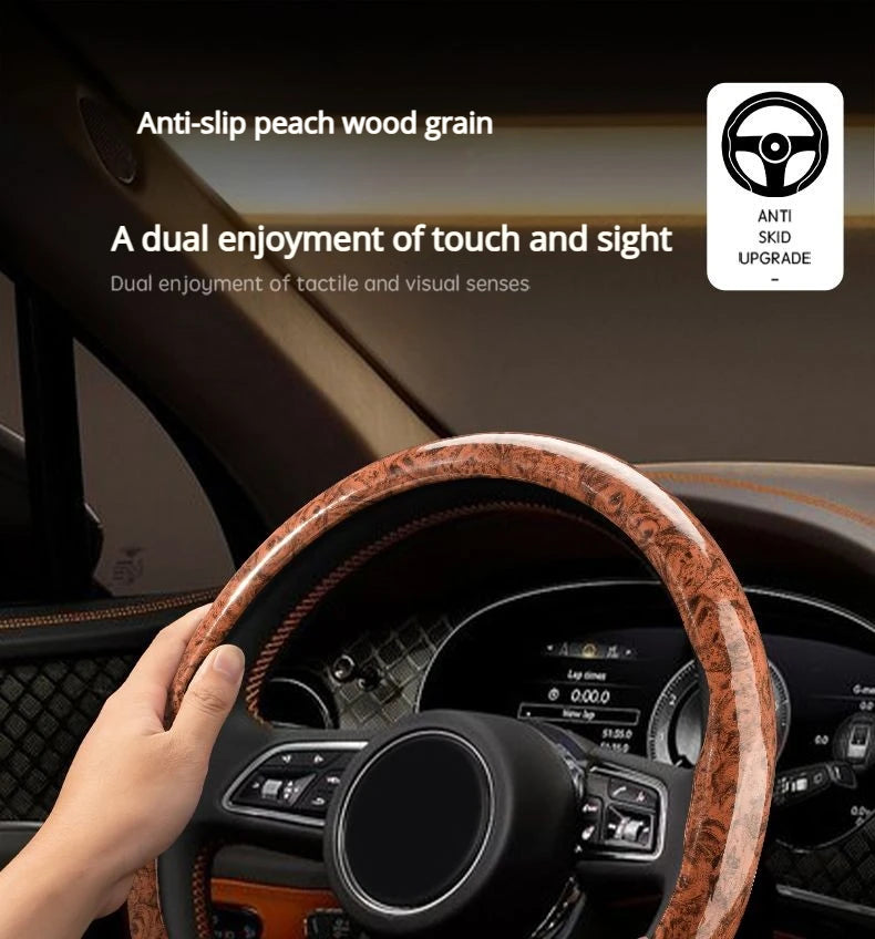 A hand grips an anti-slip steering wheel cover with peach wood grain on a car interior.